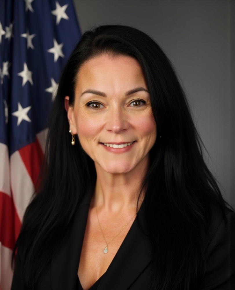 Rae O'Donnell, President and Co-Founder of Veterans Resource Alliance, smiling in a professional portrait with a U.S. flag backdrop